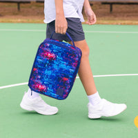 A child carrying a Montii Cosmos Large Insulated Lunch Bag on a green tennis court.