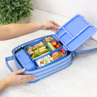A Montii Splash Stripe Large Insulated Lunch Bag with an open Montii Lunch box inside, holding a packed lunch with sandwiches, fruit, and a juice box, shown on a light countertop 