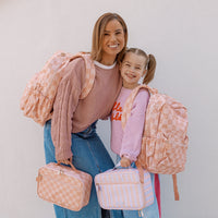 Woman and child holding matching Fox & Fallow Peach checkered bags against a plain background