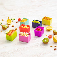 Montii Feast Silicone Cups with various snacks on a light surface