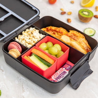 Montii Feast lunchbox with compartments filled with food items on a light surface.