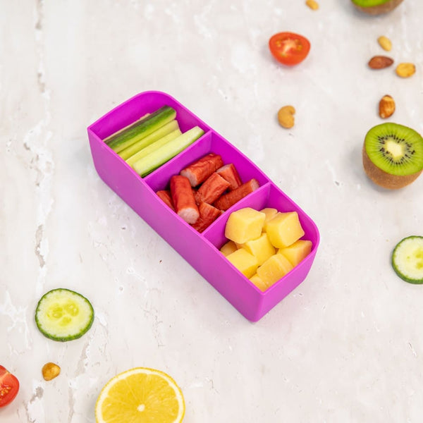 Montii Feast Tray filled with sliced vegetables and fruits on a light surface.