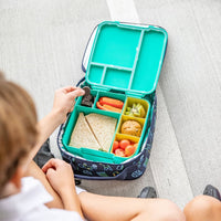 Child opening a Montii Feast bento-style lunch box with compartments filled with food.