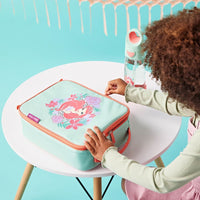 Child opening a BBox Little Mermaid Insulated Lunchbag on a small table against a bright blue background