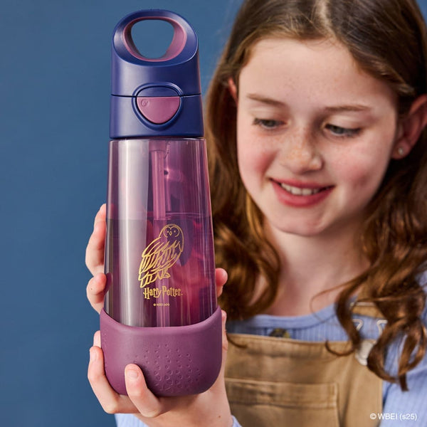 Child holding the BBox water bottle with a Harry Potter design against a blue background