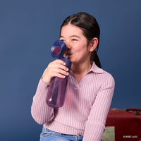 Child holding a Harry Potter bottle against a blue background