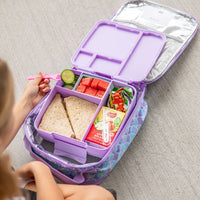 MontiiCo Lilac Feast Lunchbox with a child's hand reaching in to grab food.