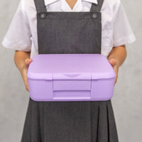 Child holding a Lilac Montii Feast lunchbox against a plain background